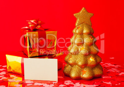 Two presents, blank card and golden evergreen tree