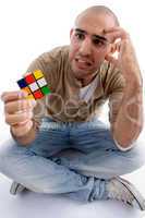 confused male holding puzzle cube