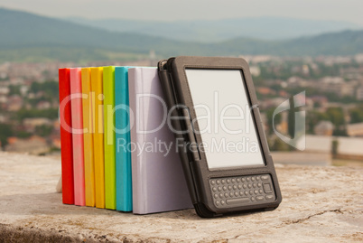 Row of colorful books with electronic book reader