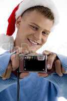 young man with christmas hat and camera