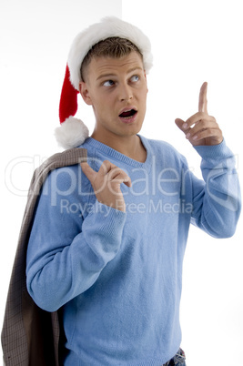 young man with christmas hat indicating upward