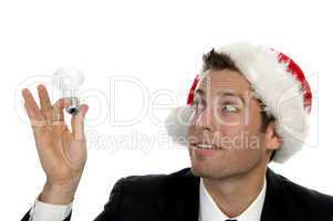 businessman holding bulb and wearing santacap