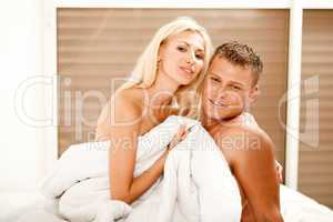 Smiling young couple in bed