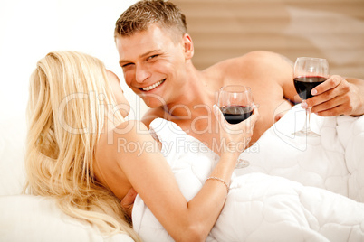 Couple enjoying wine in bed