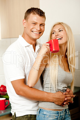 Couple in kitchen with coffee smiling