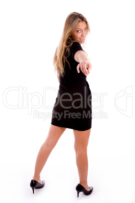 back pose of smiling woman indicating at camera