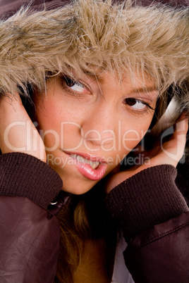 close up of adult woman with woolen coat listening music