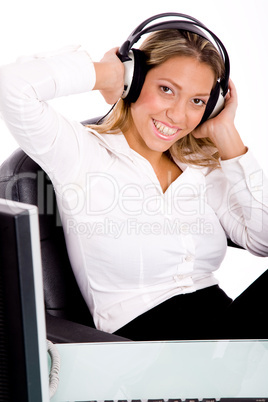 front view of smiling businesswoman listening music