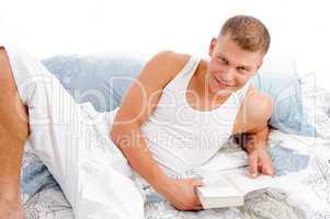 man reading book in bed
