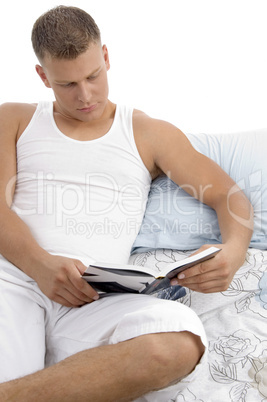 man lying on bed and reading book