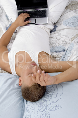 tired male lying with laptop