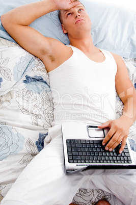 man resting at his home with laptop and looking upwards