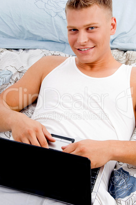 man keeping laptop on his stomach