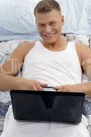 smiling laying male holding laptop