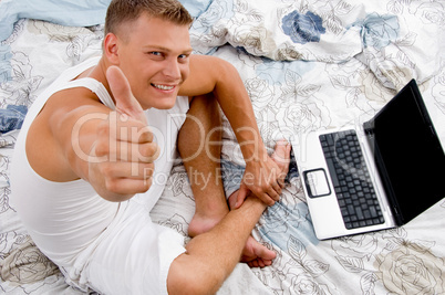 young man with thumbs up and laptop