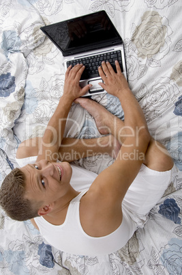 high angle view of smiling man working on notebook