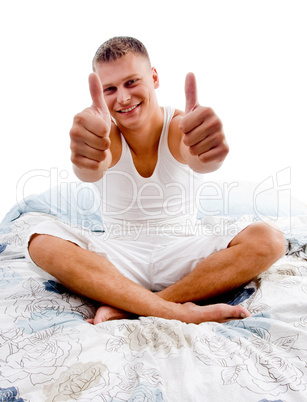 sitting young man showing thumb up with both hands