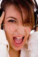 front view of screaming young woman listening music