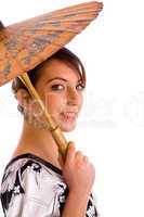 side view of smiling chineese woman holding an umbrella