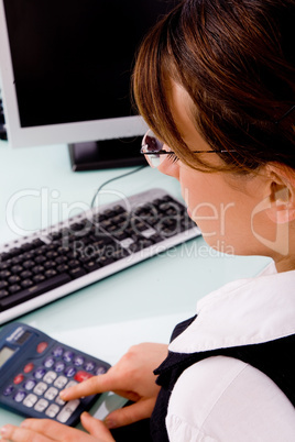 side view of businesswoman using calculator