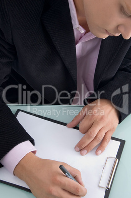 businessman writing on writing pad