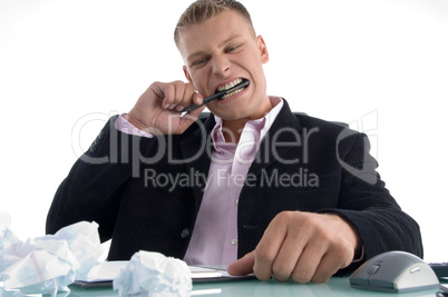 frustrated man holding pen with teeth