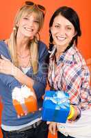 Two young woman friends hold party presents