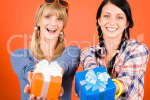 Two young woman friends hold party presents