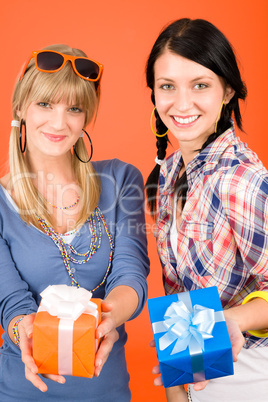 Two young woman friends hold party presents