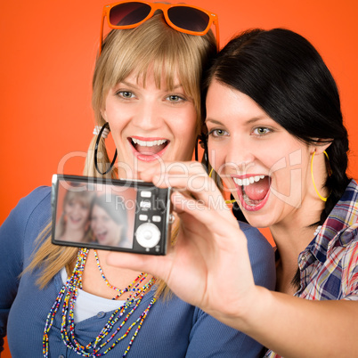 Two young woman friends taking picture smiling