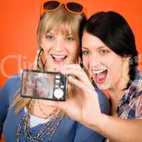 Two young woman friends taking picture smiling
