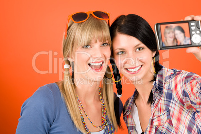 Two young woman friends taking picture smiling