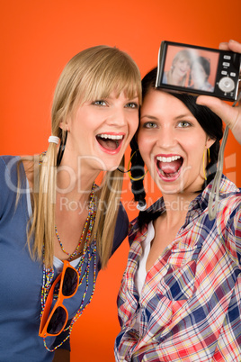 Two young woman friends taking picture smiling