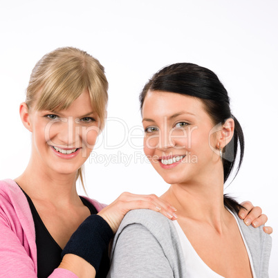 Two sport woman friends hugging smiling