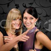 Woman friends party dress point at smiling
