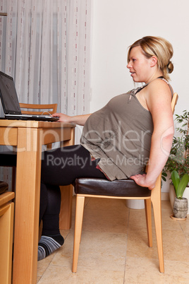 Hochschwangere Frau am Labtop