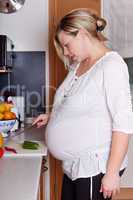 Hochschwangere Frau beim Kochen