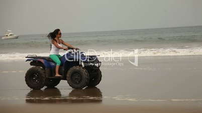 Frau fährt auf Quad am Strand