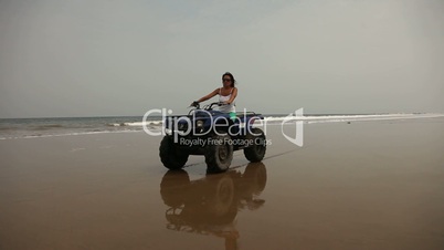 Frau fährt auf Quad am Strand