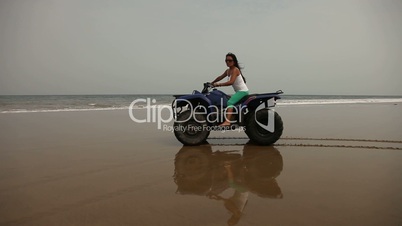 Frau fährt auf Quad am Strand