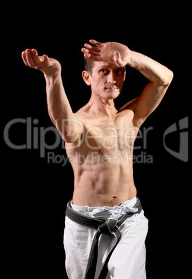 Karate. Man in a kimono with a black background