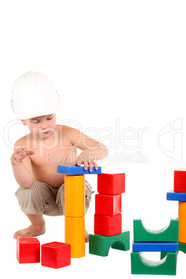 Little boy builds a house of toys on the white background