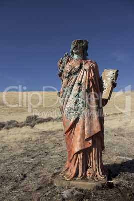 A grungy religious statue in teh middle of nowhere.