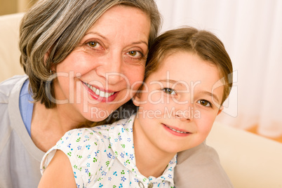 Grandmother and young girl hug together portrait