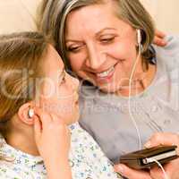Grandmother and young girl listen music together