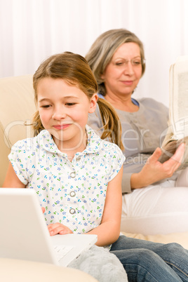 Young girl using laptop grandmother relax