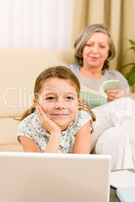 Young girl daydreaming in front of laptop