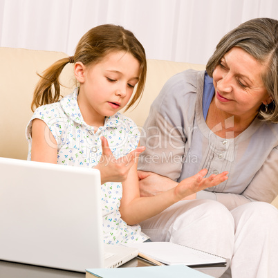 Grandmother and young girl with laptop learn count