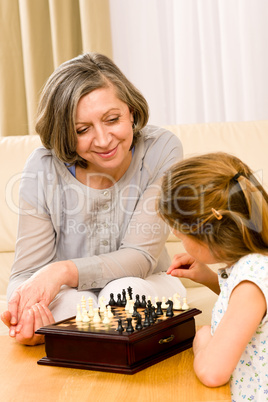 Grandmother and granddaughter play chess together