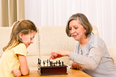 Grandmother and granddaughter play chess together